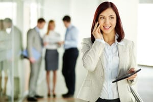 Business lady answering the phone with a smile, receiving good news